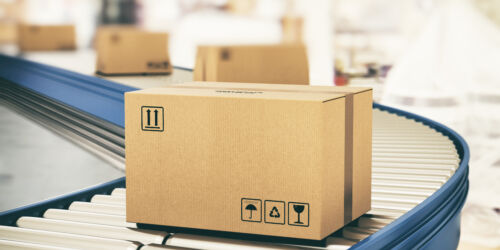 Cardboard boxes on conveyor rollers ready to be shipped by courier for distribution