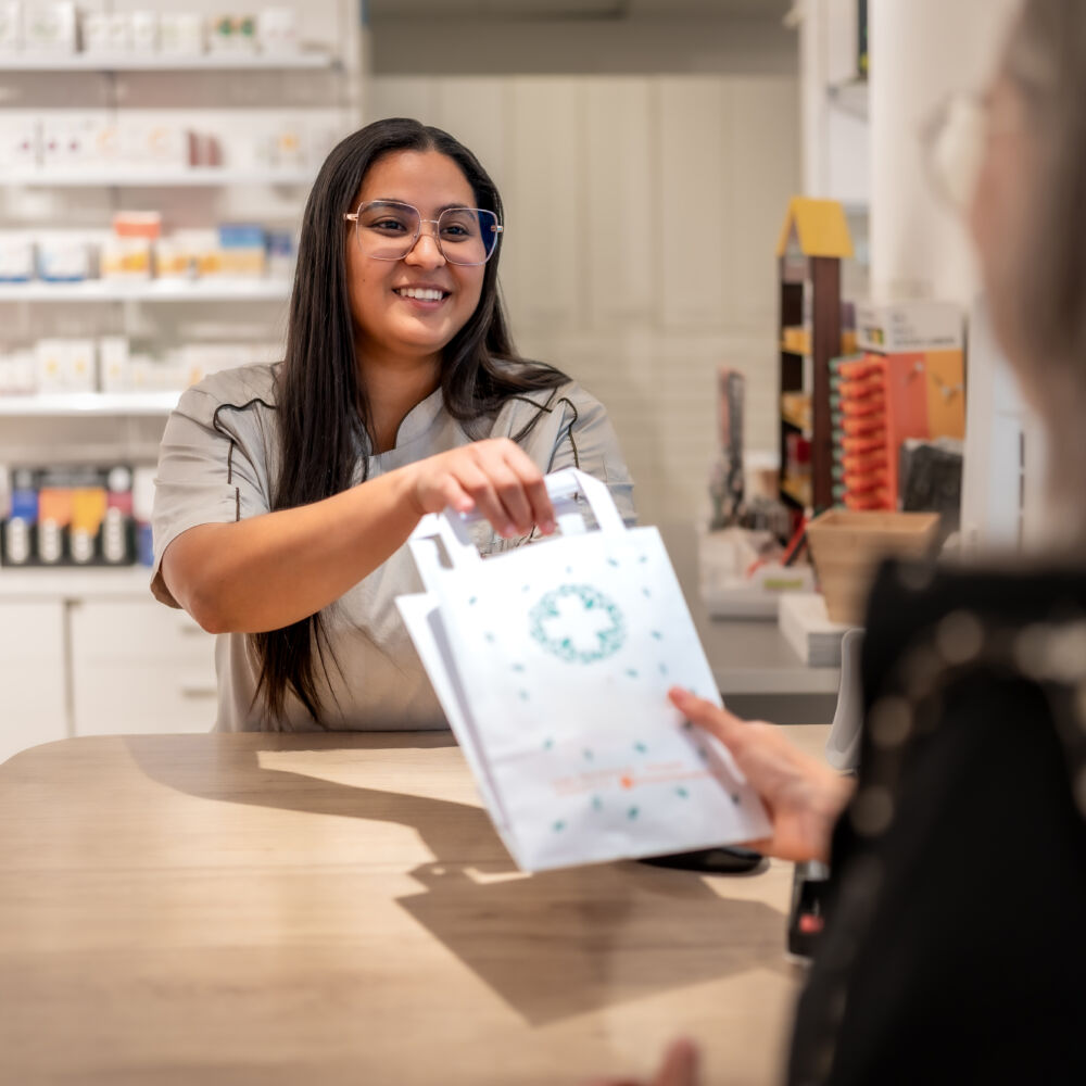 Pharmacist giving medicine to a customer at the counter